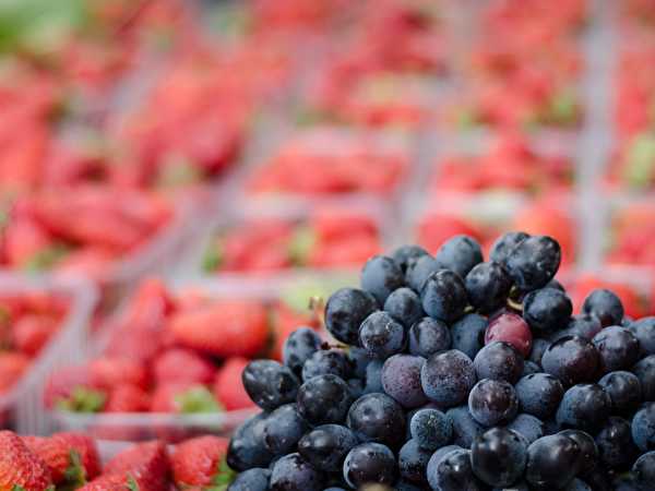 Blueberries with strawberries in the background